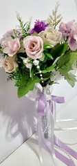 Wedding bouquet. Artificial flowers accessory with pearls and ribbons